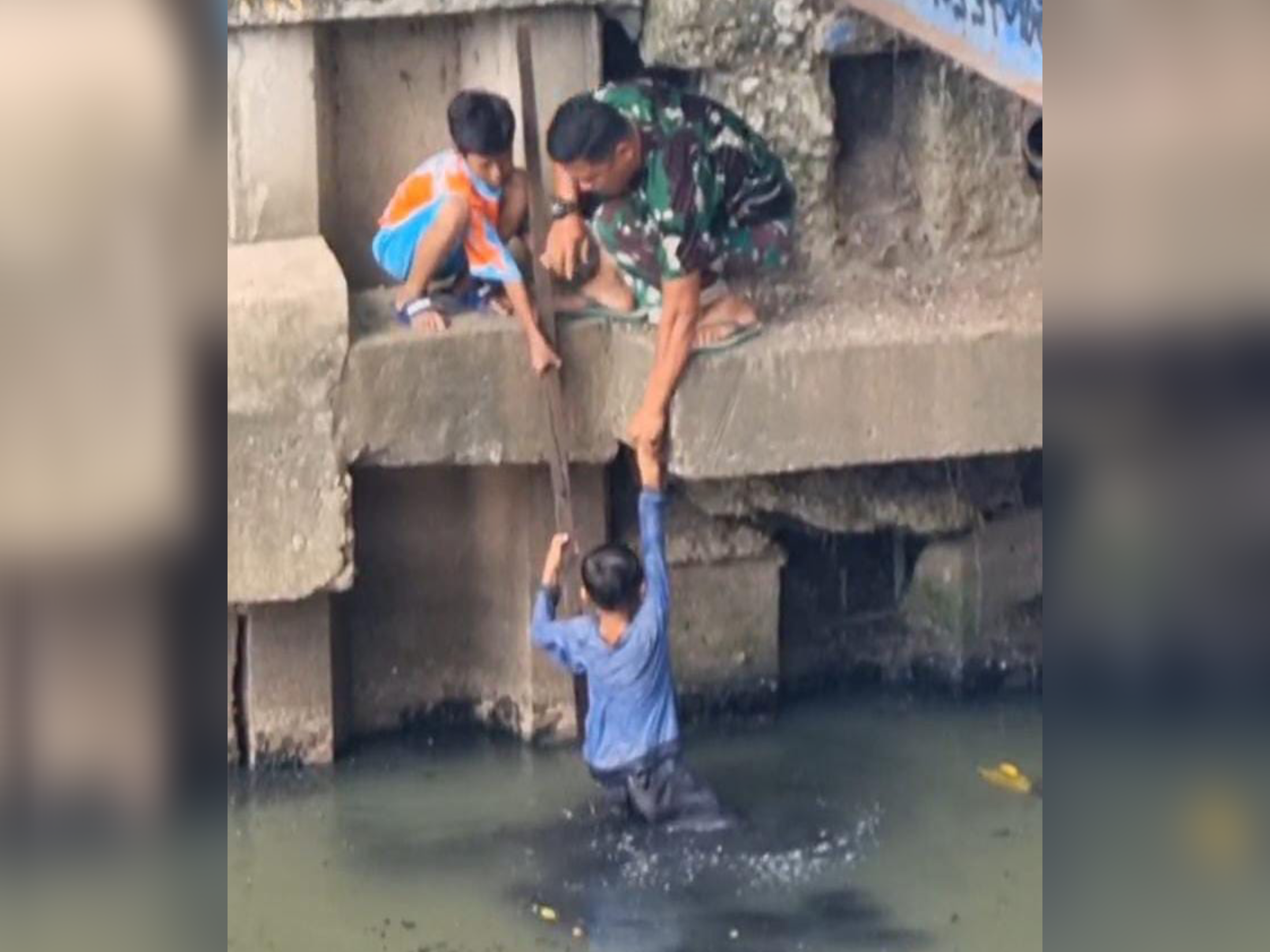 Foto: Aksi heroik ditunjukkan oleh Babinsa Koramil 07 Kemayoran, Jakarta Pusat, Sertu Wiyono, yang dengan sigap membantu proses evakuasi seorang bocah berusia sekitar 10 tahun yang tercebur di Kali Item